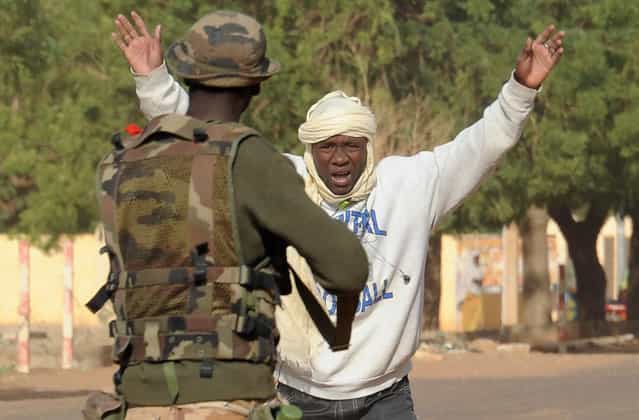 A Malian soldier arrests a man at a checkpoint one day after Islamist gunmen battled French and Malian troops, on February 11, 2013 in Gao. (Photo by Pascal Guyot/AFP Photo/The Atlantic)
