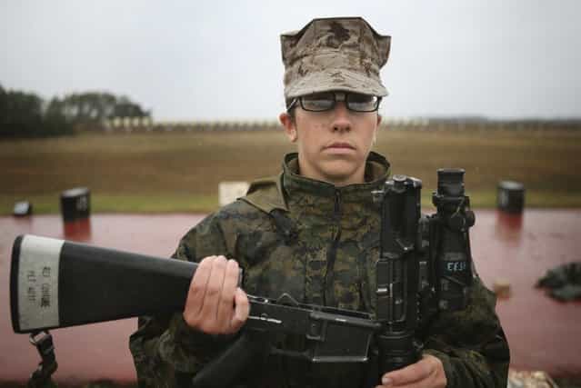 Marine recruit Melony Couture waits for her rifle to be inspected before firing on the rifle range during boot camp February 25, 2013 at MCRD Parris Island, South Carolina. Female enlisted Marines have gone through recruit training at the base since 1949. About 11 percent of female recruits who arrive at the boot camp fail to complete the training, which can be physically and mentally demanding. Females in the Marines and other branches of the armed forces have been forbidden from being assigned to ground combat units since 1994. On January 24, 2013 Secretary of Defense Leon Panetta rescinded that order. (Photo by Scott Olson/AFP Photo)