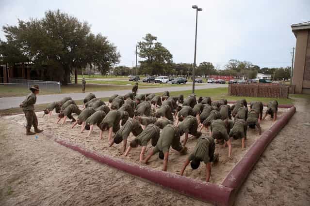 Drill Instructor SSgt. Jennifer Garza of Kerrville, Texas disciplines her Marine recruits with some unscheduled physical training in the sand pit outside their barracks during boot camp February 27, 2013 at MCRD Parris Island, South Carolina. Female enlisted Marines have gone through recruit training at the base since 1949. About 11 percent of female recruits who arrive at the boot camp fail to complete the training, which can be physically and mentally demanding. On January 24, 2013 Secretary of Defense Leon Panetta rescinded an order, which had been in place since 1994, that restricted women from being attached to ground combat units. About six percent of enlisted Marines are female. (Photo by Scott Olson/AFP Photo)