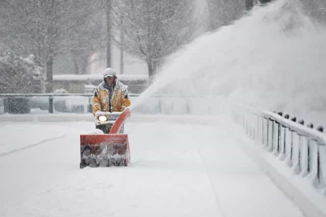 Mike Davis clears snow from the Millennium Park skating rink on March 5, 2013 in Chicago, Illinois. The worst winter storm of the season is expected to dump 7-10 inches of snow on the Chicago area with the worst expected for the evening commute. (Photo by Brian Kersey/AFP Photo)