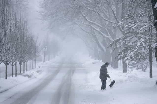 John Baer of Elgin, Ill. finishes shoveling half of his driveway on Wing Park Ave. during a snow storm in the suburbs of Chicago, Ill. on Tuesday, March 5, 2013. (Photo by Daily Herald, Brian Hill/AP Photo)