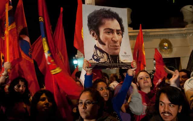 Holding sign with image of Simón Bolívar, Chileans manifest themselves after the announcement of the death of Hugo Chavez. (Photo by Claudio Santana/AFP Photo)