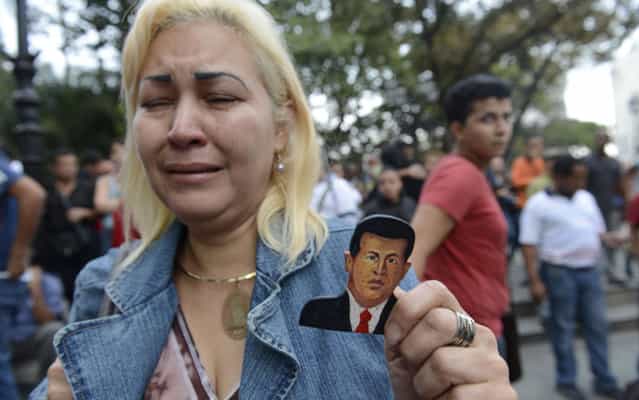 A supporter of Venezuelan President Hugo Chavez cries after knowing of his death in Caracas on March 5, 2013. (Photo by Juan Barreto/AFP Photo)