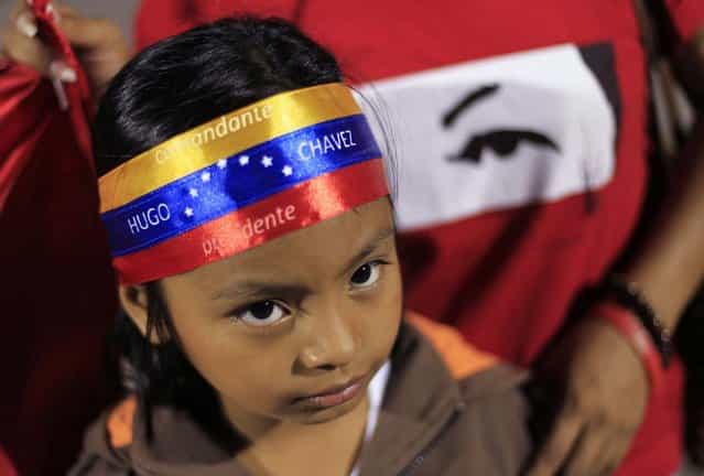 A young supporter of Venezuela's President Hugo Chavez wears a headband that reads [Commander Hugo Chavez, President] while standing at a square in San Salvador March 5, 2013. Chavez died on Tuesday after a two-year battle with cancer, ending 14 years of tumultuous rule that made the socialist leader a hero for the poor but a hate figure to his opponents. (Photo by Ulises Rodriguez/Reuters)