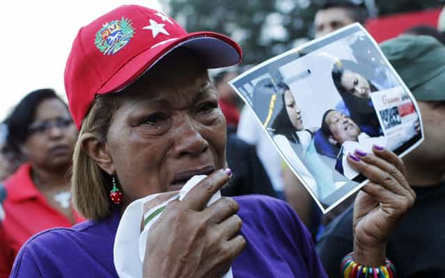 With photo in hand of Hugo Chavez, Venezuelan weeps after the announcement of the death of the country's president. (Photo by Carlos Garcia Rawlins/Reuters)