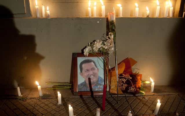 Candles are lit in front of portrait of Hugo Chávez, in demonstration in front of the Venezuelan Embassy in Santiago, Chile. (Photo by Claudio Santana/AFP Photo)