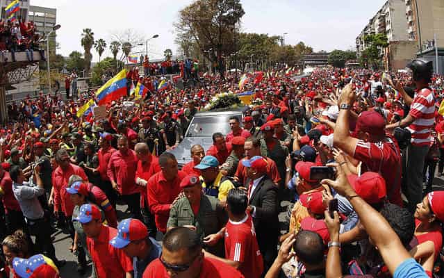 Crowd accompanies the procession carrying the coffin of Chávez in Caracas. (Photo by Carlos Garcia Rawlins/Reuters)