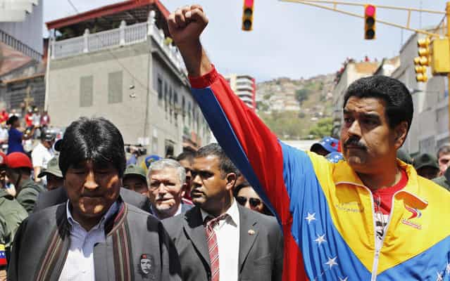 Venezuela's Vice President Nicolas Maduro (R) and Bolivia's President Evo Morales (L) walk ahead of the vehicle carrying the coffin of deceased Venezuelan leader Hugo Chavez, as it is driven through the streets of Caracas after leaving the military hospital where he died of cancer in Caracas, March 6, 2013. Authorities have not yet said where Chavez will be buried after his state funeral on Friday. (Photo by Carlos Garcia Rawlins/Reuters)
