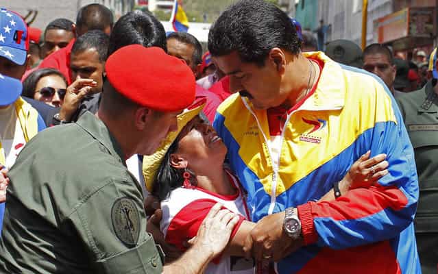 Venezuela's Vice President Nicolas Maduro consoles a supporter of deceased Venezuelan leader Hugo Chavez, as his coffin is driven through the streets of Caracas, March 6, 2013. Authorities have not yet said where the late Venezuelan President Chavez will be buried after his state funeral on Friday. (Photo by Carlos Garcia Rawlins/Reuters)