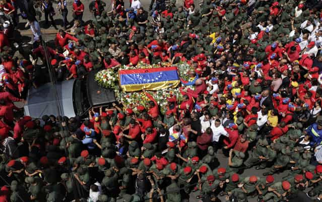 Military escort the passage of the procession through the streets of Caracas. (Photo by Ariana Cubillos/AP Photo)