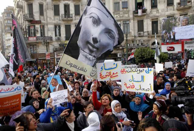 Egyptian women wave a flag showing pharaoh Queen Hatshepsut, the only woman that ruled Egypt, and anti-Muslim Brotherhood banners during a demonstration in Cairo, Egypt, Friday, March 8, 2013, marking International Women's Day. Arabic reads, [women with revolution], [women are owner of a message]. (Photo by Amr Nabil/AP Photo)