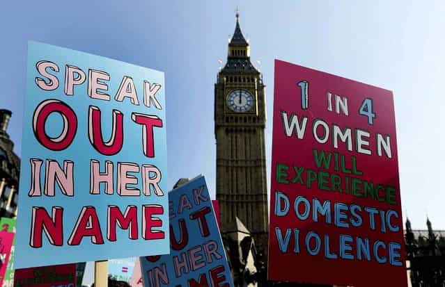 People hold banners during a demonstration against domestic violence near Big Ben in the lead up to International Women's Day, in London on Tuesday. Avon, Refuge and Women's Aid are launching a new campaign called [Speaking Out In Her Name] to raise awareness of domestic violence. (Photo by Kirsty Wigglesworth/Associated Press)
