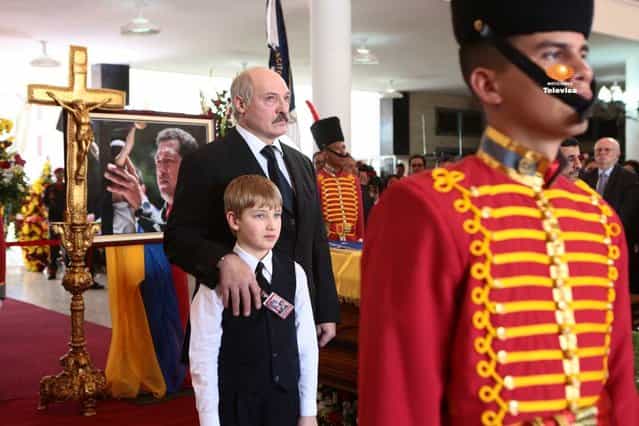 President of Belarus Alexander Lukashenko and his son Nikolai, stand next to the flag-draped coffin of late Venezuela's President Hugo Chavez during the funeral ceremony at the military academy in Caracas on March 8, 2013. (Photo by Marcelo Garcia/Miraflores Press via AP Photo)