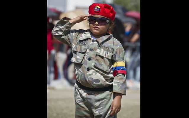 The child dressed as Hugo Chávez, salutes on March 8, 2013. (Photo by Ronaldo Schemidt/AFP Photo)