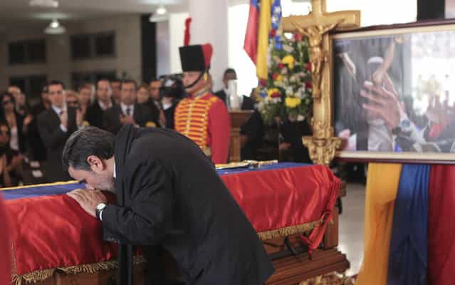 Iran's President Mahmoud Ahmadinejad pays tribute to late Venezuelan President Hugo Chavez, during the funeral service at the Military Academy in Caracas March 8, 2013, in this picture provided by the Miraflores Palace. Chavez will be embalmed and put on display [for eternity] at a military museum after a state funeral and an extended period of lying in state, acting President Nicolas Maduro said on Thursday. (Photo by Miraflores Palace/Reuters)