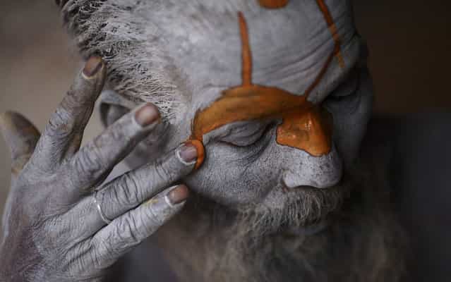 A ascetic, wandering monk (Sadhu) prepares itself for ritual in Pashupatinath temple, to Kathmandu, Nepal, on March 4, 2013. (Photo by Navesh Chitrakar/Reuters)