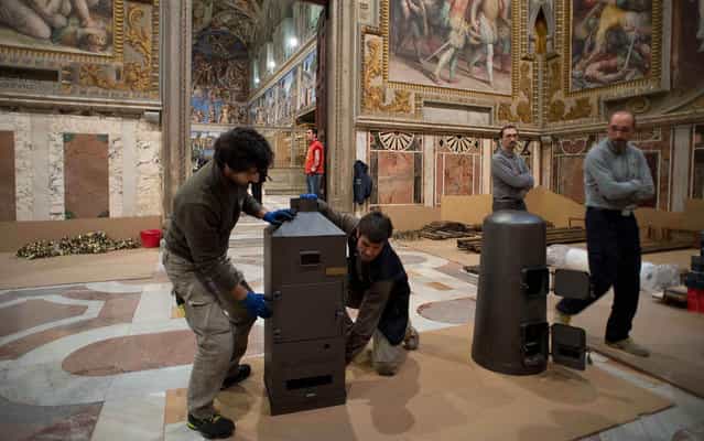 Workers prepare the stoves that will be used to burn the ballots during the next conclave in the Sistine Chapel at the Vatican in this photo released by Osservatore Romano March 7, 2013. (Photo by Osservatore Romano/Reuters)