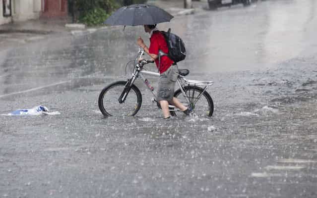 Cyclist on the street, flooded in the district of the Ipiranga, in the Southern District of Sao Paulo, March 8, 2013. (Foto by Edson Lopes Jr./Folhapress)