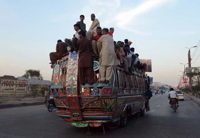 Pakistani passengers travel on a over loaded mini bus in Karachi on March 6, 2013. Karachi went on an indefinite strike , with businesses, shops, schools and transporters ordered to shutdown until police arrest those responsible for the city's worst bomb attack in years. The Muttahida Qaumi Movement (MQM), which controls most of Pakistan's largest city, ordered the strike three days after a powerful car bomb killed 50 people and wounded around 140 others in Shiite Muslim neighbourhood Abbas Town. (Photo by Asif Hassanasif Hassan/AFP Photo)