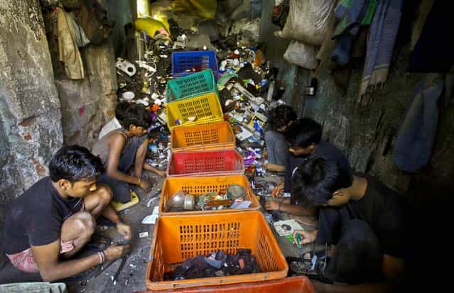 Workers sort scraps at a factory in a Dharavi slum in Mumbai, India, on March 7, 2013. (Photo by Rafiq Maqbool/Associated Press)