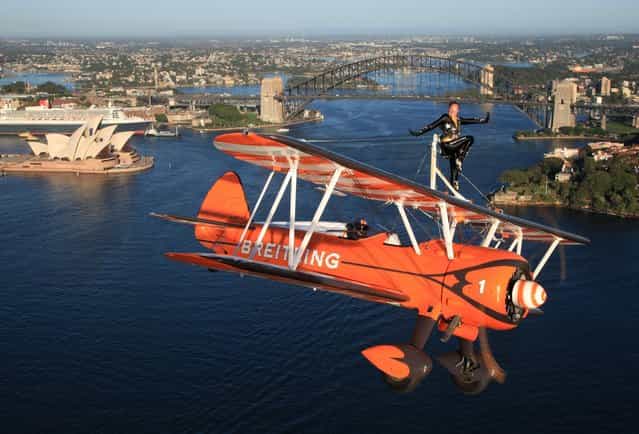 Breitling Wingwalker Sarah Tanner, from the UK, performs over Sydney Harbour in what is the first visit to the southern hemisphere by the UK based Breitling Wingwalker team in Sydney, Australia, on Thursday, March 7, 2013. The Stearman biplane, piloted by Martyn Carrington, performed an aerial display in front of the iconic Sydney Opera House and Sydney Harbour Bridge. (Photo by Michael Jorgensen for Breitling via AP Images)