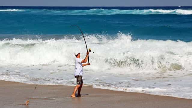 Josh Jorgensen, Founder and Director of the Blacktip Challenge Shark Fishing Tournament, casts for sharks on Midtown Beach. (Photo by Lannis Waters/Palm Beach Daily News)