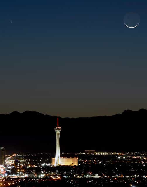 The comet PanSTARRS, above and to the left, passes over the Stratosphere Casino Hotel along with a waxing crescent moon at twilight over the Spring Mountains range on March 12, 2013 in Las Vegas, Nevada. Officially known as C/2011 L4, the comet got its name after being discovered by astronomers using the Panoramic Survey Telescope & Rapid Response System (Pan-STARRS) telescope in Hawaii in June 2011. (Photo by Ethan Miller)