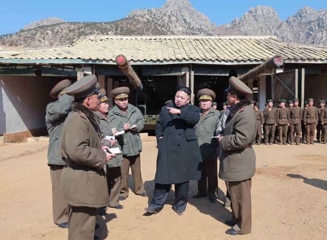 In this March 11, 2013 photo released by the Korean Central News Agency (KCNA) and distributed March 12, 2013 by the Korea News Service, North Korean leader Kim Jong Un, center, confers with military officers at a long-range artillery sub-unit of KPA Unit 641 during his visit to front-line military units near the western sea border in North Korea near the South's western border island of Baengnyeong. Kim urged front-line troops to be on [maximum alert] for a potential war as a state-run newspaper said Pyongyang had carried out a threat to cancel the 1953 armistice that ended the Korean War. (Photo by AP Photo/KCNA via KNS)