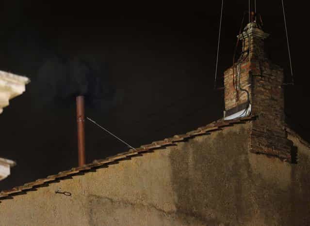 Black smoke emerges from the chimney on the roof of the Sistine Chapel, indicating that the cardinals did not elect a new pope on March 12, 2013. (Photo by Dmitry Lovetsky/Associated Press)