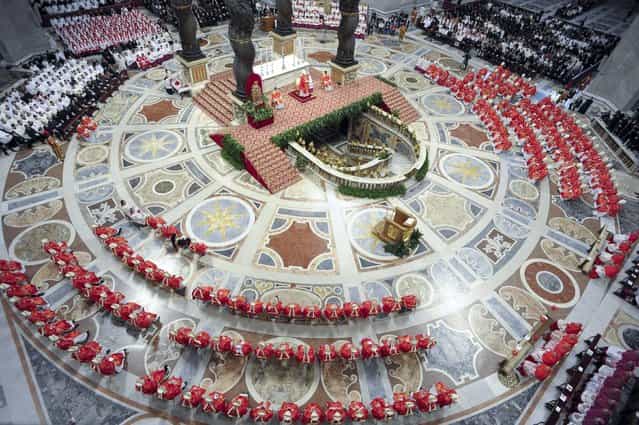 In this photo provided by the Vatican newspaper L'Osservatore Romano, cardinals, in red, attend a Mass for the election of a new pope celebrated by Cardinal Angelo Sodano, figure at the center of the stage beneath the Bernini baldachin, inside St. Peter's Basilica, at the Vatican, Tuesday, March 12, 2013. Cardinals enter the Sistine Chapel on Tuesday to elect the next pope amid more upheaval and uncertainty than the Catholic Church has seen in decades: There's no front-runner, no indication how long voting will last and no sense that a single man has what it takes to fix the many problems. (Photo by L'Osservatore Romano, ho/AP Photo)
