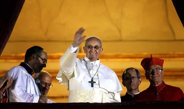 Pope Francis waves to the crowd from the central balcony of St. Peter's Basilica at the Vatican, March 13, 2013. Cardinal Jorge Bergoglio of Argentina, who chose the name of Francis, is the 266th pontiff of the Roman Catholic Church. (Photo by Gregorio Borgia/Associated Press)
