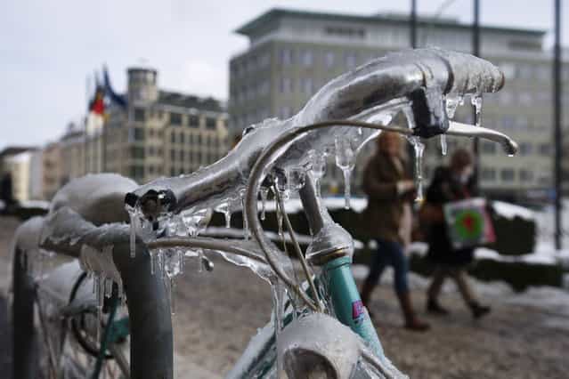Icycles hang from a bike standing in Berlin on March 12, 2013. Winter came back to wide parts of the country, bringing snow and cold temperatures. (Photo by Emily Wabitsch/AFP Photo)