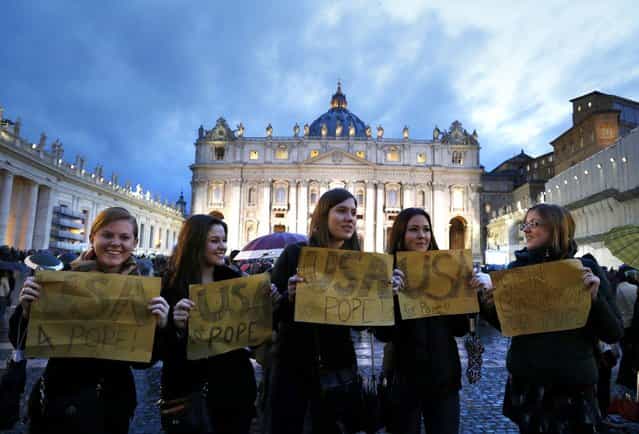 Women hold placards in support of the election of a U.S. cardinal to be named as pope, outside Saint Peter's Basilica and the Sistine Chapel at the Vatican March 12, 2013. Roman Catholic Cardinals began their conclave inside the Vatican's Sistine Chapel today to elect a new pope. (Photo by Stefano Rellandini/Reuters)