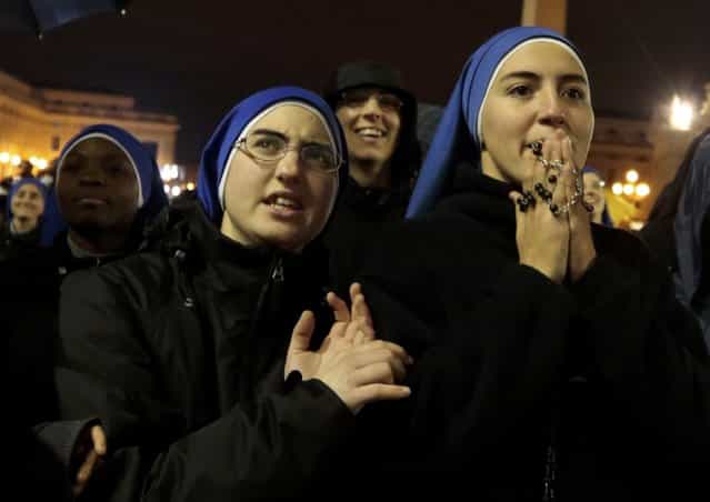Nuns react as black smoke rises from the chimney above the Sistine Chapel, indicating that no decision has been made after the first day of voting for the election of a new pope, in the Vatican City, March 12, 2013. Roman Catholic Cardinals began their conclave inside the Vatican's Sistine Chapel today to elect a new pope. (Photo by Eric Gaillard/Reuters)