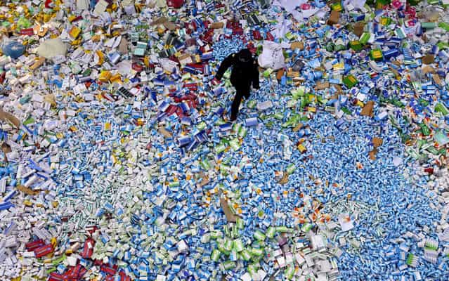 This picture taken on March 14 shows a Chinese policeman walking across a pile of fake medicines seized in Beijing in recent months, which were later destroyed. The rapid growth of Internet commerce has led to an explosion of counterfeit drugs sold around the world, with China the biggest source of fake medicines, pharmaceutical experts said as the illicit trade is now believed to be worth around 75 billion USD globally, with criminal gangs increasingly using the web to move their products across borders. (Photo by AFP Photo)