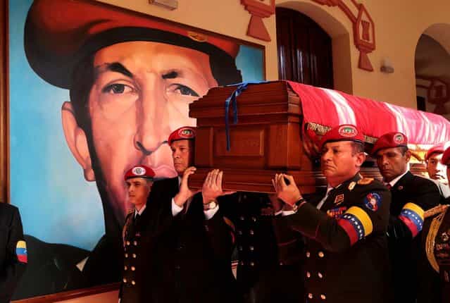 Soldiers who served with Hugo Chavez carry his coffin inside the military museum, Chavez's final resting place, where a mural of Chavez covers a wall, on March 15, 2013. (Photo by Miraflores Press Office)