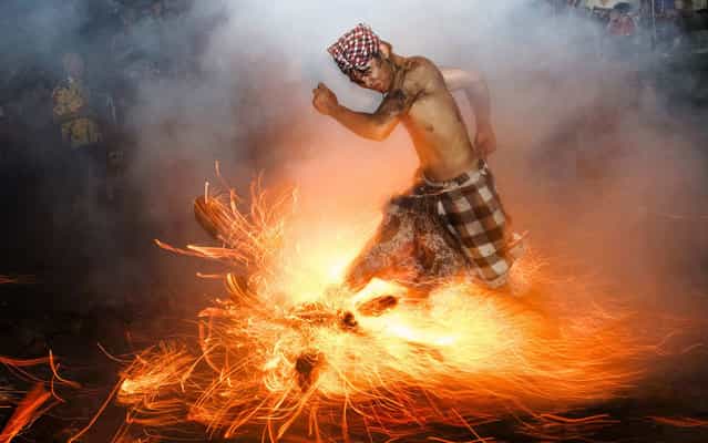 A Balinese man kicks up fire during the [Perang Api] ritual ahead of Nyepi day, which falls on Tuesday in Gianyar on the Indonesian island of Bali, on March 12, 2013. Nyepi is a day of silence for self-reflection to celebrate the Balinese Hindu new year, where Hindus in Bali observe meditation and fasting, but are not allowed to work, cook, light lamps or conduct any other activities. (Photo by Reuters/Stringer)