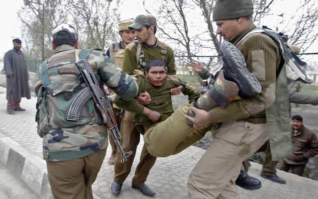 Indian paramilitary soldiers carry their injured colleague to a hospital during the gunfight in Srinagar, on March 13, 2013. (Photo by Danish Ismail/Reuters)