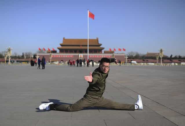 A hotel security guard poses for pictures in front of China's national flag at Tiananmen Square during the third plenary session of the National People's Congress (NPC) in Beijing March 10, 2013. (Photo by Stringer/Reuters)