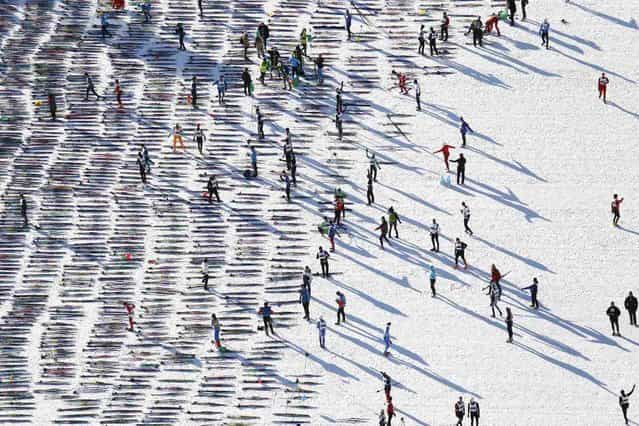 An aerial view shows cross-country skiers awaiting the start of the Engadin Ski Marathon on the frozen Lake Sils near the village of Maloja March 10, 2013. More than 12,000 skiers participated in the 42.2 km (26.2 miles) race between Maloja and S-chanf near the Swiss mountain resort of St. Moritz. (Photo by Michael Buholzer/Reuters)