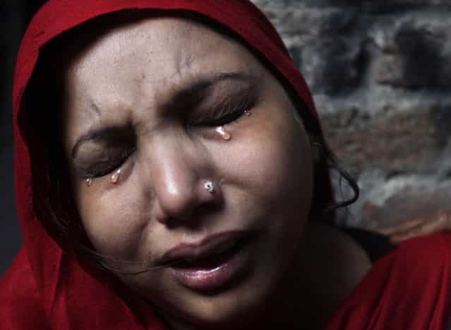 A Pakistani Christian woman weeps after visiting her home which was damaged by an angry Muslim mob in Lahore, Pakistan, Sunday, March 10, 2013. Hundreds of Christians clashed with police in eastern and southern Pakistan on Sunday, a day after a Muslim mob burned dozens of homes owned by members of the minority religious group in retaliation for alleged insults against Islam's Prophet Muhammad. (Photo by K.M. Chaudary/AP Photo)