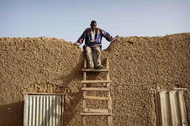 Local resident Fada Yarga prepares to climb down a ladder at his residence, a traditional mud brick house, in Gao March 11 2013. (Photo by Joe Penney/Reuters)