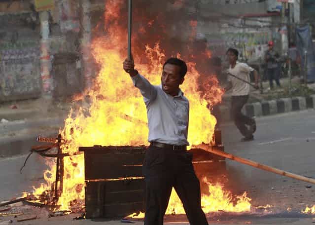 An activist of Jamaat-e-Islami gestures to the police during a clash in Dhaka March 11, 2013. Around 50 people have been arrested as police raided the office of the Bangladesh Nationalist Party (BNP) following a violent clash with activists of the BNP and its ally Jamaat-e-Islami after a scheduled rally, local media reported. (Photo by Andrew Biraj/Reuters)
