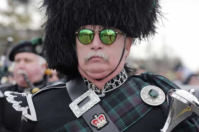A drum major leads a bagpipe marching band during the Queens County St. Patrick's Day Parade in the Rockaway section of New York, Saturday, March 2, 2013. The ocean side community was devastated by flooding and fire during Superstorm Sandy. (Photo by Mark Lennihan/AP Photo)