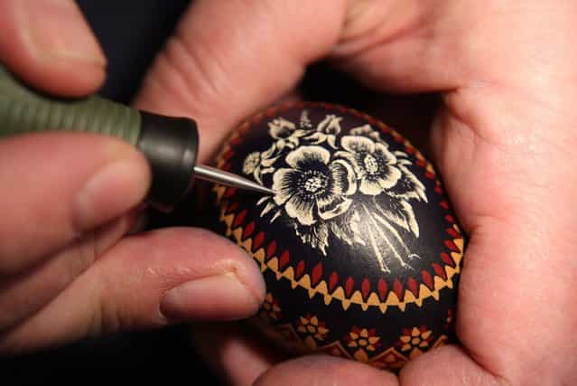 A Sorb egg painter engraves an Easter egg at the annual Easter egg market on March 16, 2013 in Schleife, Germany. Easter is a particularly important time of year for Sorbs, a Slavic minority in eastern Germany, and the period includes the tradition of painting Easter eggs that include visual elements intended to ward off evil. Many Sorbs still speak Sorbian, a language closely related to Polish and Czech. (Photo by Adam Berry)