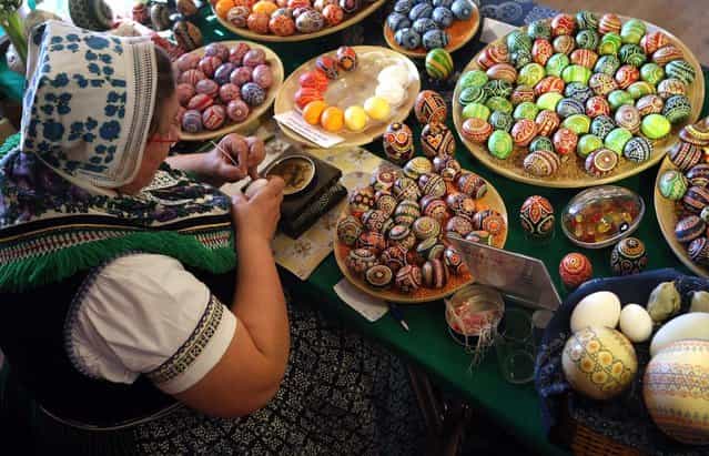 Sorb egg painter Kerstin Hanusch decorates eggs at the annual Easter egg market on March 16, 2013 in Schleife, Germany. Easter is a particularly important time of year for Sorbs, a Slavic minority in eastern Germany, and the period includes the tradition of painting Easter eggs that include visual elements intended to ward off evil. Many Sorbs still speak Sorbian, a language closely related to Polish and Czech. (Photo by Adam Berry)