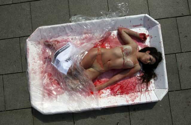 A ativista posou apenas de calcinha e sutiã, com o que aparenta ser sangue falso sobre o corpo (Foto by Albert Gea/Reuters)