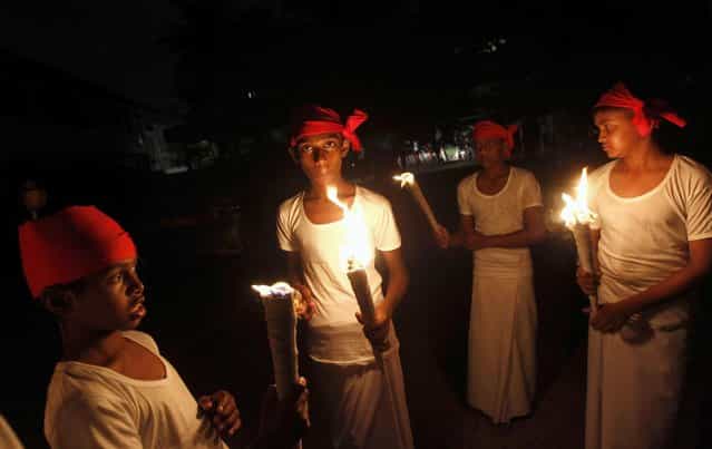 Sri Lankan youths hold up torches to mark Earth Hour in Colombo March 23, 2013. EarthHour, when everyone around the world is asked to turn off lights for an hour from 8.30 p.m. local time, is meant as a show of support for tougher action to confront climate change. (Photo by Dinuka Liyanawatte/Reuters)