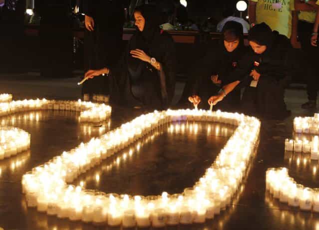 Emiratis light candles to mark Earth Hour near Burj Khalifa in Dubai, March 23, 2013. Earth Hour, when everyone around the world is asked to turn off the lights for an hour from 8.30pm local time, is meant as a show of support for tougher actions to combat climate change. (Photo by Jumana El Heloueh/Reuters)