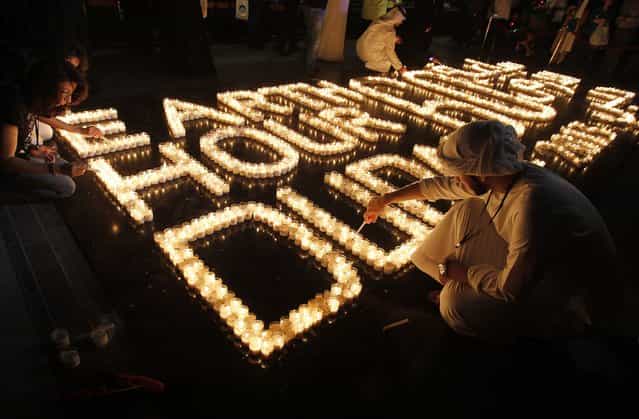 Emiratis light candles to mark Earth Hour near Burj Khalifa in Dubai, March 23, 2013. Earth Hour, when everyone around the world is asked to turn off the lights for an hour from 8.30pm local time, is meant as a show of support for tougher actions to combat climate change. (Photo by Jumana El Heloueh/Reuters)